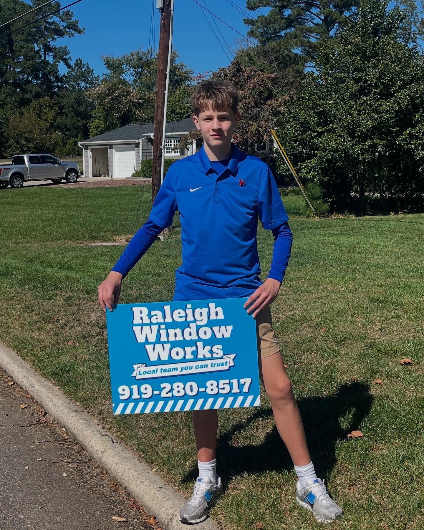 Raleigh Window Works team member with company yard sign